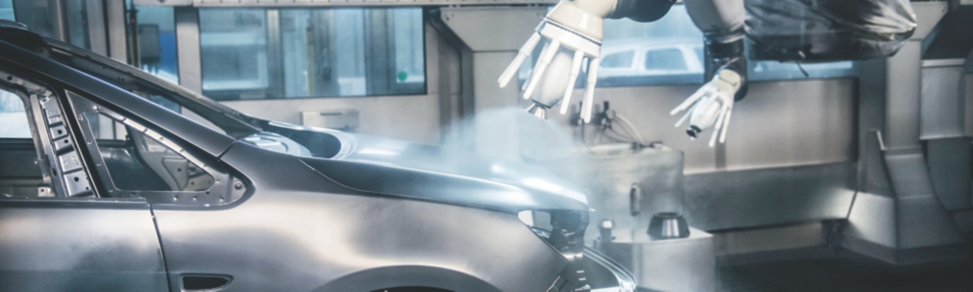 Robotic arm applying coating to automobile frame
