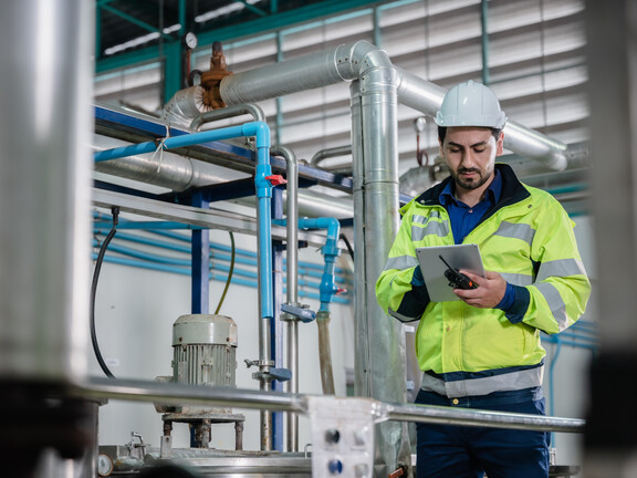 Engineer looking at tablet in HVAC room
